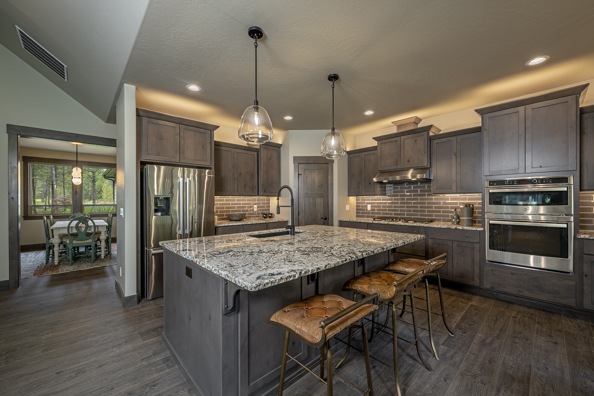 The kitchen includes dark trim surrounded by dark tile.  The black- and-white theme continues in the granite island